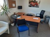 un bureau et une chaise dans une pièce où il y a un tableau accroché au mur