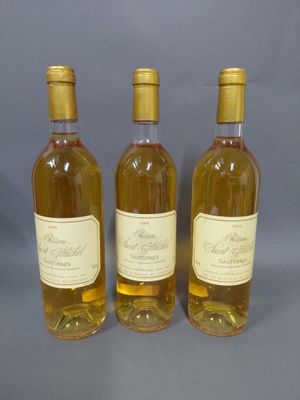 trois bouteilles de vin posées l'une à côté de l'autre sur une table