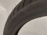 a close up of a tire on a white surface with a sky in the background