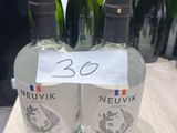 trois bouteilles de vin Neuvix posées sur une table, avec d'autres bouteilles de vin en arrière-plan