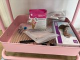 a pink cart that has a lot of items in it