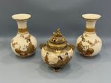 three white and gold vases with birds and flowers on them