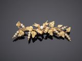 a close up of a gold and pearl flower broochle