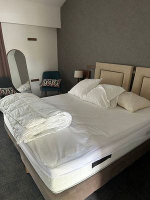 un lit avec une couette blanche et des oreillers dans une chambre