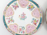 three plates with floral designs on them on a white surface