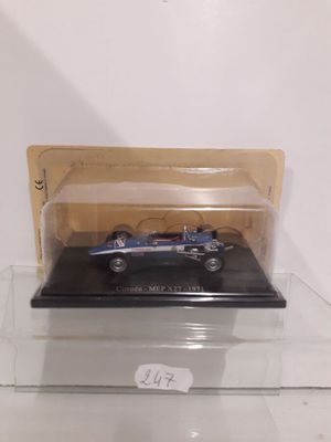 a small blue car in a clear box on a table