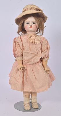 an old fashioned doll with a hat and dress on a stand