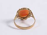 a close up of a gold ring with an orange stone in it