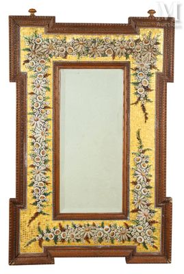 une image représentant un miroir doté d'un cadre en bois orné d'un motif floral