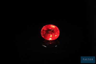 une boule rouge posée sur une surface noire dans l'obscurité
