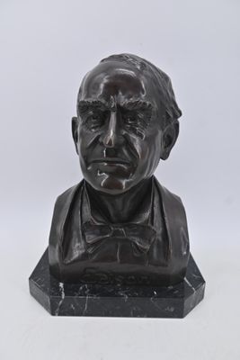 statue représentant le buste d'un homme portant un nœud papillon, posée sur un socle en marbre