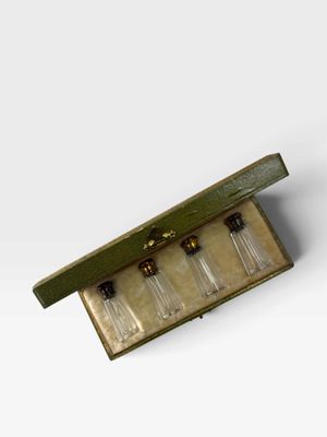 une boîte en bois contenant trois petites bouteilles en verre