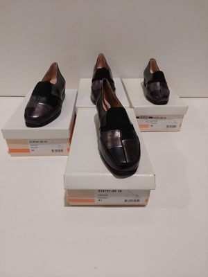 trois paires de chaussures noires exposées sur une table