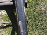 a black pipe sticking out of the ground next to a chair