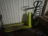 un chariot élévateur jaune garé à côté d'une pile de bois