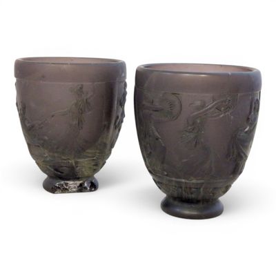 two vases sitting next to each other on a white surface