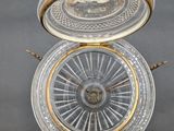 a silver and gold plate with a clock on it