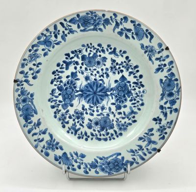 une assiette bleue et blanche ornée d'un motif floral