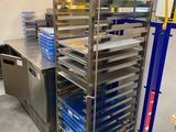 de nombreux plateaux de nourriture posés sur un chariot métallique dans la cuisine