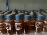 many bottles of liquid sitting on a shelf