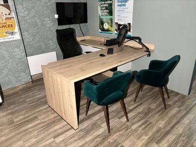 a desk with two chairs and a computer on it