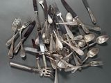 a pile of silverware on a table with forks and spoons