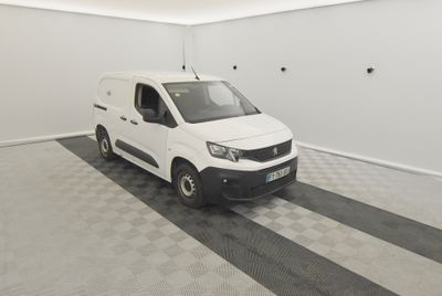 La camionnette blanche est garée dans le garage de l'immeuble.