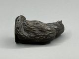 un petit objet en métal sur lequel est représenté un oiseau