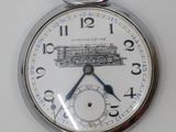a silver pocket watch with a train on it