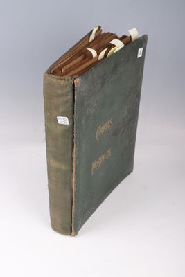 un livre vert ouvert sur une surface blanche