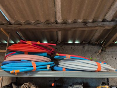 many different colored hoses on a shelf in a garage