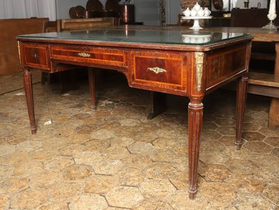 un bureau en bois avec un plateau en verre dans une pièce