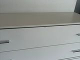 une commode blanche dans un coin de la pièce