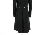 a black coat on a mannequin stand on a white surface