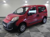 the small red van is parked on a checkered tile floor