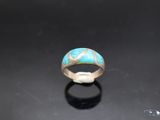 a ring with a turquoise stone in the middle of it