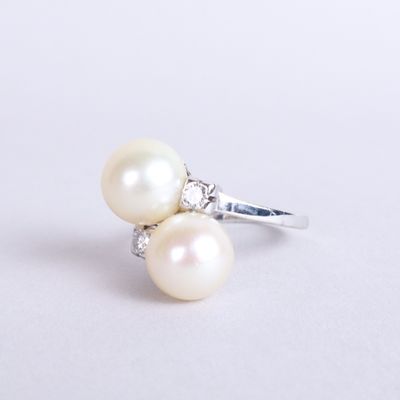 an image of a pearl and diamond ring on a white surface