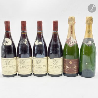 six bouteilles de vin sont alignées sur une surface blanche