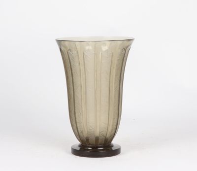Le vase est en verre et repose sur un socle en bois.