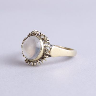 un gros plan sur une bague en or sertie d'une pierre blanche