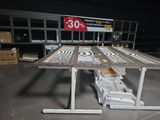 une table sur laquelle est posée une pancarte, dans un entrepôt