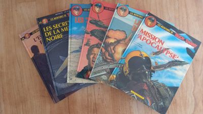 four books on a wooden table, one of which has a picture of a man in a helmet and the other of which is a man in a helmet