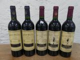 six bouteilles de vin sont alignées sur une table en bois
