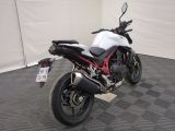 a white and red motorcycle parked on a black and white checkered floor