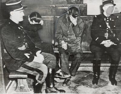 three men sitting on a bench in a room with a man in a gas mask on his face