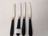 three black and white knives and a knife holder on a white surface