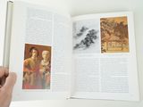 someone is holding a book open to a picture of a woman and a man