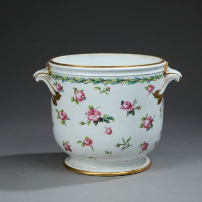 a white vase with pink flowers on it on a table