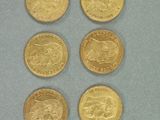 six types différents de pièces d'or posées sur un fond bleu