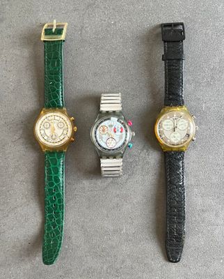 trois montres sont assises l'une à côté de l'autre sur une table